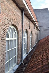 <p>Overzicht van de vensterreeks in de zuidgevel van het kerkgebouw. Het metselwerk is in het midden duidelijk onderbroken met een bouwnaad. </p>
